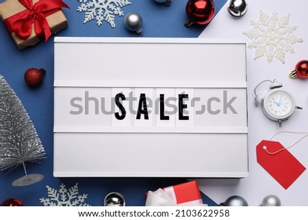Lightbox with word Sale, gifts and Christmas decorations on color background, flat lay