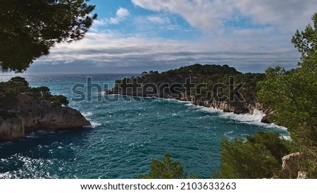 Panoramic view over popular bay Calanque de Port-Miou near Cassis at the French Riviera in Calanques National Park with rocks covered by green pine trees on sunny day in autumn with rough sea.