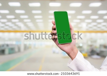Businesswoman holding mobile smart phone at factory industry.