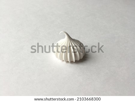 White meringue drop on white background close-up. Space for text