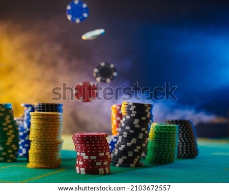 Casino. Online casino. On a multicolored smoky background, stacks of multicolored playing chips. Levitation. Close-up. There are no people in the photo. Gambling business, poker, night club. Royalty-Free Stock Photo #2103672557