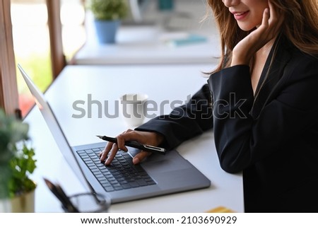 Cropped shot smiling businesswoman working with laptop computer.