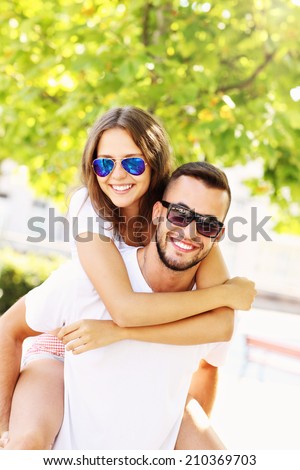 A picture of a happy couple doing piggyback in the park