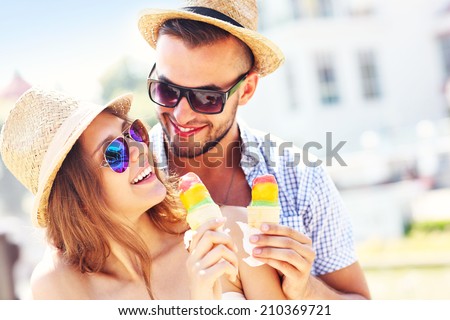 A picture of a lovely couple eating ice-cream in the city