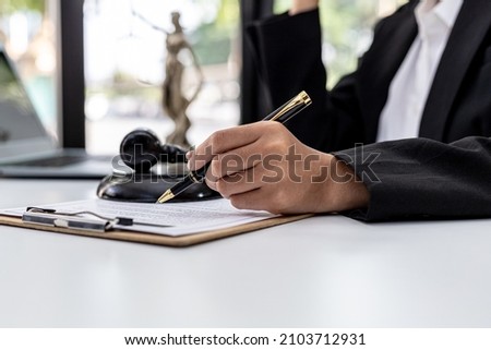 A male lawyer is signing a plea agreement with a client in a fraud case, in which the client has filed a lawsuit against an employee at a company that commits the fraud. Fraud litigation concept. Royalty-Free Stock Photo #2103712931