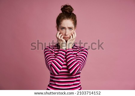 Studio shot of young woman with sad face 
