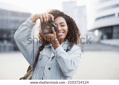 Woman photographer with dslr camera taking pictures outdoor. Mixed race girl with photo camera outdoor. Home hobby, lifestyle, travel, people concept Royalty-Free Stock Photo #2103724124