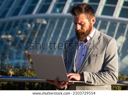 handsome businessman with laptop in the city