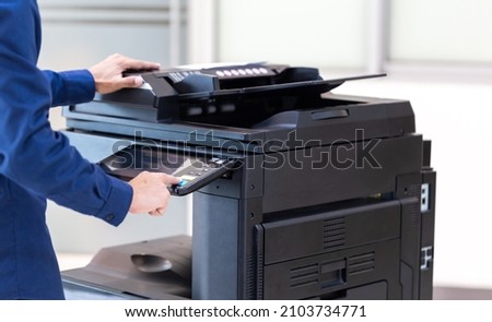Businessman press button on panel of printer photocopier  network , Working on photocopies in the office concept , printer is office worker tool equipment for scanning and copy paper. Royalty-Free Stock Photo #2103734771