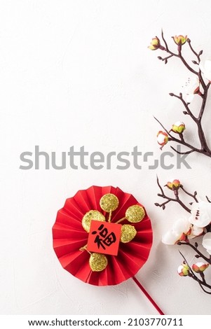 Top view of Chinese lunar new year background copy space design concept with white plum flower and festive decoration, the word inside picture means blessing.