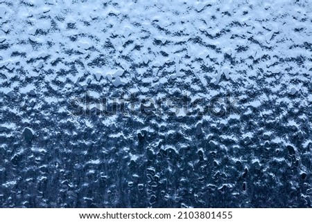 Ice-covered window glass close-up, may be usad as background