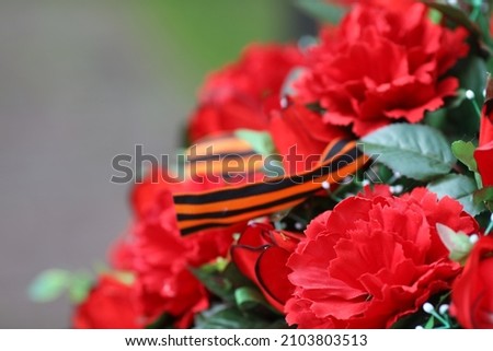 Beautiful red flowers on the victory day, 9 of May,  army sign, red tulips   Royalty-Free Stock Photo #2103803513