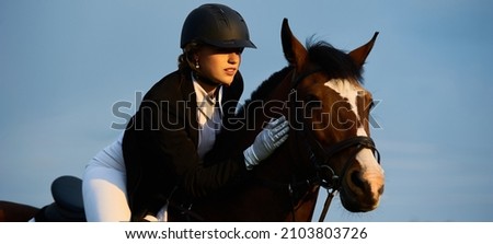 Girl equestrian rider riding a beautiful horse  in the rays of the setting sun. Horse theme Royalty-Free Stock Photo #2103803726