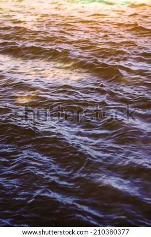 sky with clouds reflected on the water surface with waves
