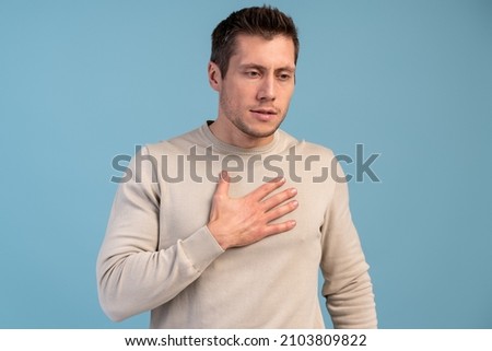People, healthcare and problem concept. Waist up of caucasian man suffering from heart ache over blue background  Royalty-Free Stock Photo #2103809822