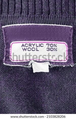 Fabric composition clothing label on purple knit background