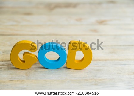 Colorful wooden word God on wooden floor