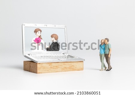 Miniature people Bride and groom virtual wedding on computer screen, Happy Valentines Day concept