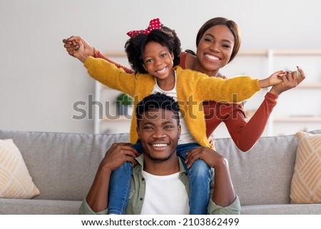 Family Leisure. Happy Black Mom, Dad And Little Daughter Having Fun At Home Together, African American Father, Mother And Cute Female Child Playing In Living Room And Smiling At Camera, Free Space Royalty-Free Stock Photo #2103862499