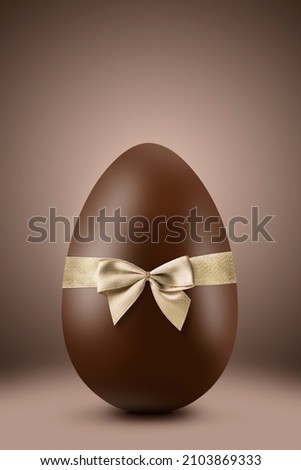 Chocolate easter egg with gold ribbon on brown background Royalty-Free Stock Photo #2103869333