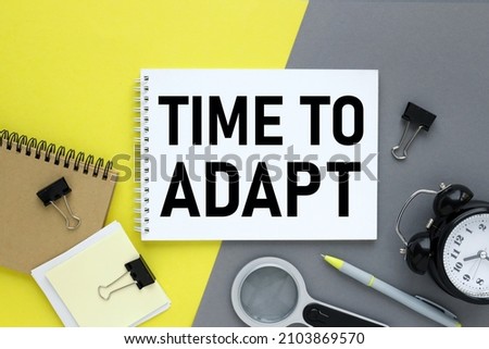 TIME FOR ADAPT. Concept for management and business.Open laptop and other office supplies Yellow and gray