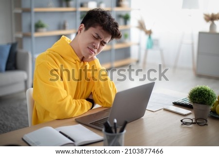 Neck Pain. Exhausted Asian Man Massaging Aching Neck Suffering From Ache Sitting Working At Laptop At Desk In Living Room At Home Office. Osteoarthritis, Health Problem, Sedentary Lifestyle Concept Royalty-Free Stock Photo #2103877466