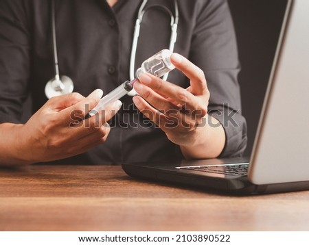 A doctor is holding a vaccine bottle and syringe. Vaccine for prevention and treatment from virus infection. Close-up photo. Concept of medical and the fight against the virus Royalty-Free Stock Photo #2103890522