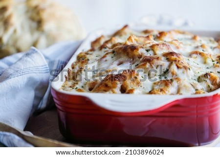 Delicious homemade backed tortellini noodle casserole topped with chopped fresh parsley and melted golden mozzarella cheese. Selective focus with blurred foreground and background. 