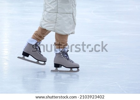 Ice skating on an ice rink. legs with skates. Winter active sport and leisure hobby.