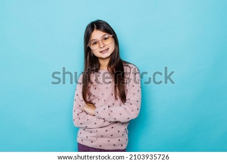 Portrait of caucasian teen girl against blue background.