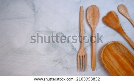 Wooden spoon and wooden fork on the table. Wooden kitchenware that gives a classic and minimalist impression. Food and drink concept. Food Photography. Flat Lay, Top View. High Angle view.