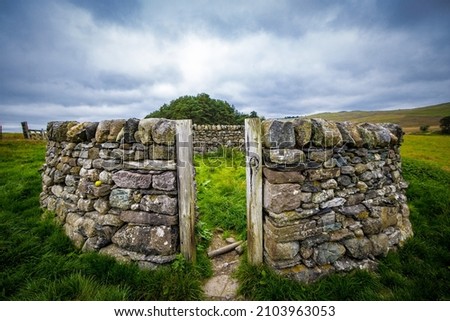 Circular dry stone wall in a field  Royalty-Free Stock Photo #2103963053