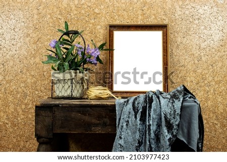 still life: empty picture frame mockup on wooden old desk table. purple flowers vase and rope and gray textile. Elegant working space, home office concept
