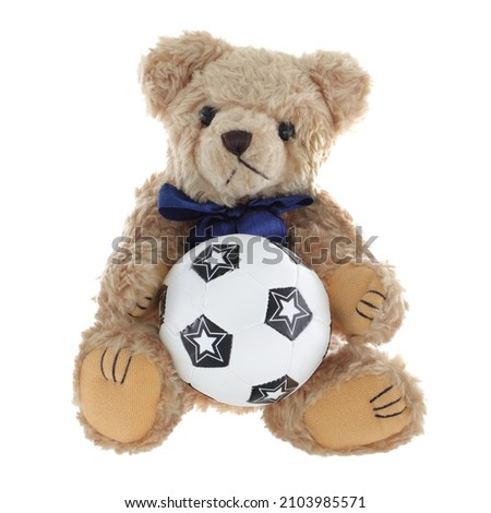 Cute teddy bear holding a football soccer ball