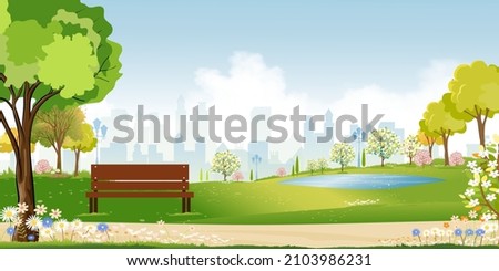 Spring landscape at city park in the morning, Natural public park with flowers blooming in the garden, Peaceful scene of green fields with blurry cityscape building, cloudy and sun on summer Royalty-Free Stock Photo #2103986231
