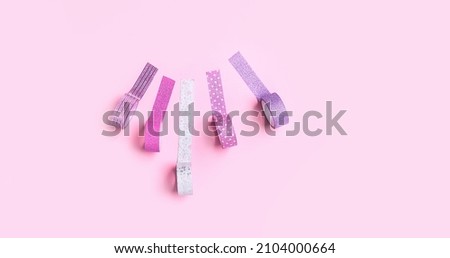 set of shiny sticky decorative tapes on pink background. bright washi tapes, stationery for scrapbooking, creativity, wrapping, festive packing. creative minimal style. template for design. banner Royalty-Free Stock Photo #2104000664
