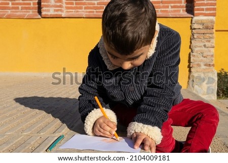 Child painting a drawing at school recess. Concept of child in school. Creativity.
