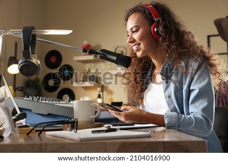 African American woman working as radio host in modern studio
