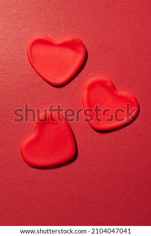Valentine card. Red hearts on a red paper background. Vertical photo.