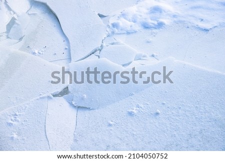 Snow and broken ice on a frozen lake surface, natural winter background photo