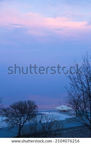 Dusk twilling on the Black sea in Odessa city beach. Early spring, blue evening, water horizon merging with sky in blue tranquil evening. Vertical photo with free copy space for text