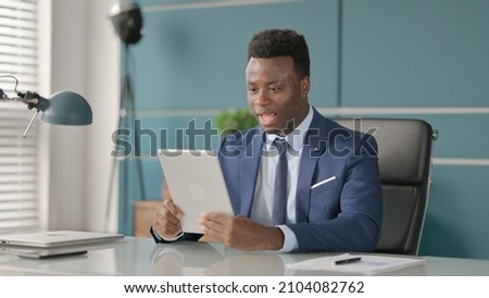 African Businessman making Video Call on Tablet in Office 