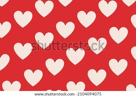 Wooden natural hearts as pattern on bright red background. Valentine holiday ready for romance. Minimal virtual love concept.