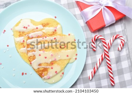 Two pancakes with condensed milk. Breakfast for lovers. A festive snack for Valentine's Day. Copy space. Flat lay, top view.