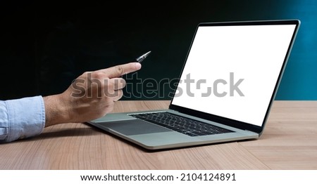 Businessman hand holding pen to display laptop with white background mock up on display and clipping path