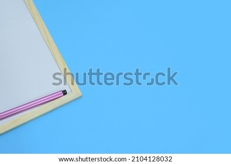 Selective Focus of Colourful Magic Ink Pens On A Wooden White Board Isolated with Blue Background For Education or Presentation Background Use