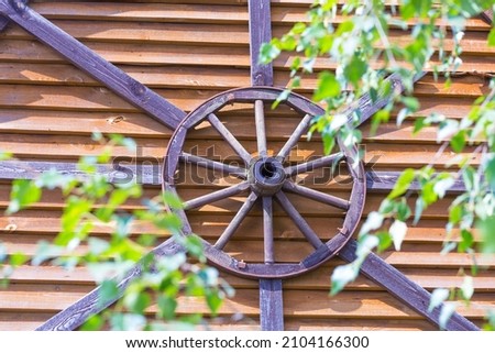 an old wooden wheel from a cart, a symbol of the sun, an ancient amulet of a summer residence