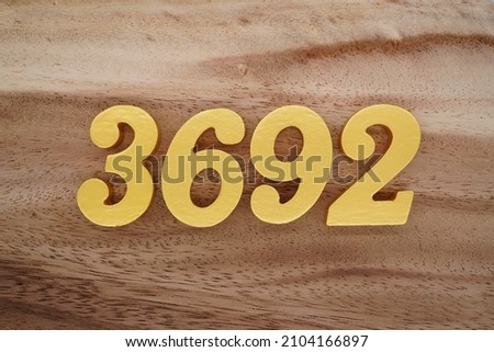 Golden Arabic numerals 3692 on a dark brown to white wood grain background.