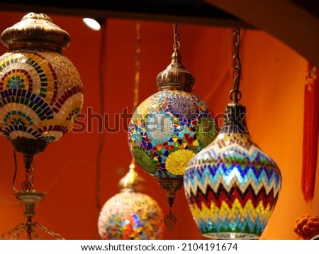 Mosaic colorful exotic glass decorations in orange background. Travel tourism and business concept photo. Colorful decorations hanging on the roof indoor view.