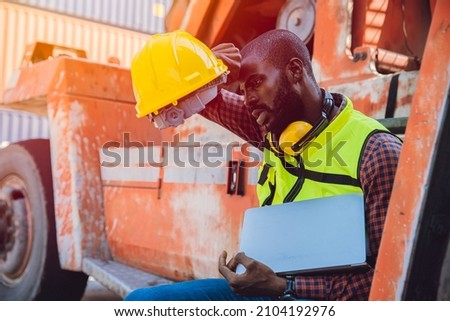 Tired stress worker sweat from hot weather in summer working in port goods cargo shipping logistic ground, Black African race people. Royalty-Free Stock Photo #2104192976